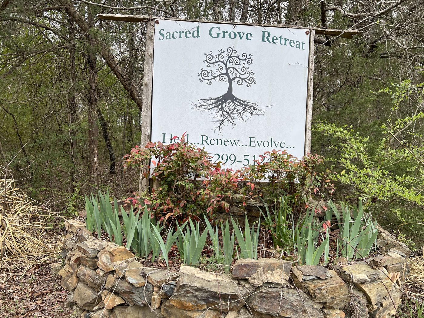 The Sacred Grove Retreat entrance sign reading Heal, Renew, Evolve